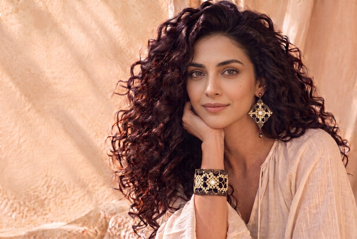 Model wearing a diamond-shaped earring and matching embroidered cuff
